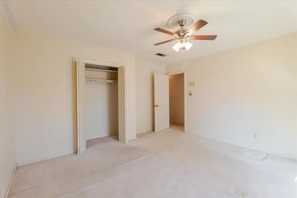 a view of an empty room with a ceiling fan