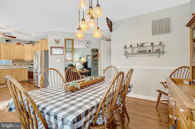a dining room with furniture a chandelier and wooden floor