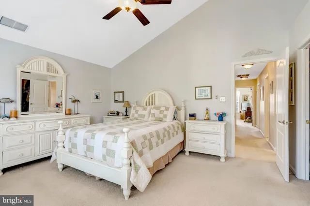a large white bed sitting in a bedroom and table