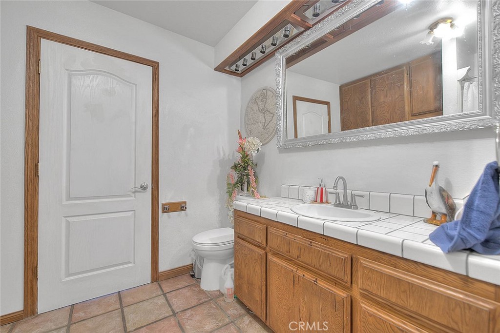 8529 Nielson Road Phelan, CA 92371 - Photo 22 of 44 a bathroom with a granite countertop sink mirror vanity and toilet