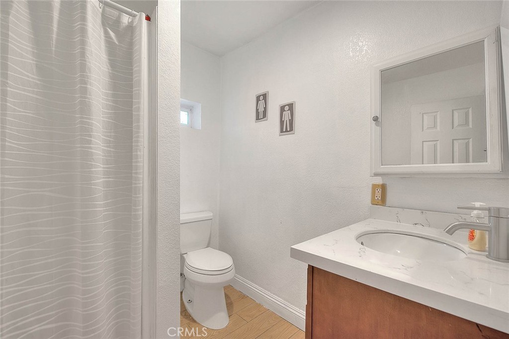 8529 Nielson Road Phelan, CA 92371 - Photo 37 of 44 a bathroom with a sink a toilet and shower curtain