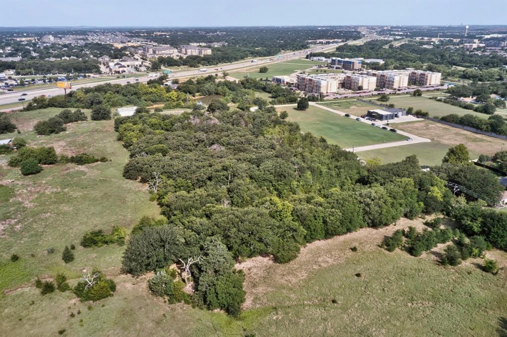 0 Dobbs Road Corinth, TX 76208 - Photo 10 of 16 Expansive land parcel featuring mature tree coverage, open grassy areas, and proximity to highway infrastructure