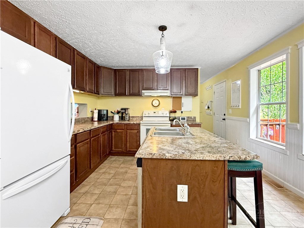 1173 Hopewell Church Road Boone, NC 28607 - Photo 5 of 39 a kitchen with stainless steel appliances granite countertop a sink a stove a refrigerator cabinets and wooden floor