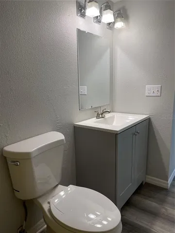 a bathroom with a toilet a sink and mirror