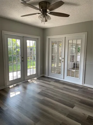 a view of an empty room with wooden floor and a window