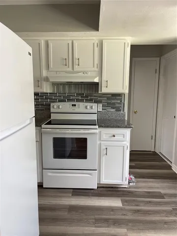 a kitchen with white cabinets and white appliances