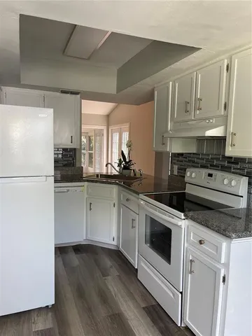 a kitchen with stainless steel appliances white cabinets and a refrigerator