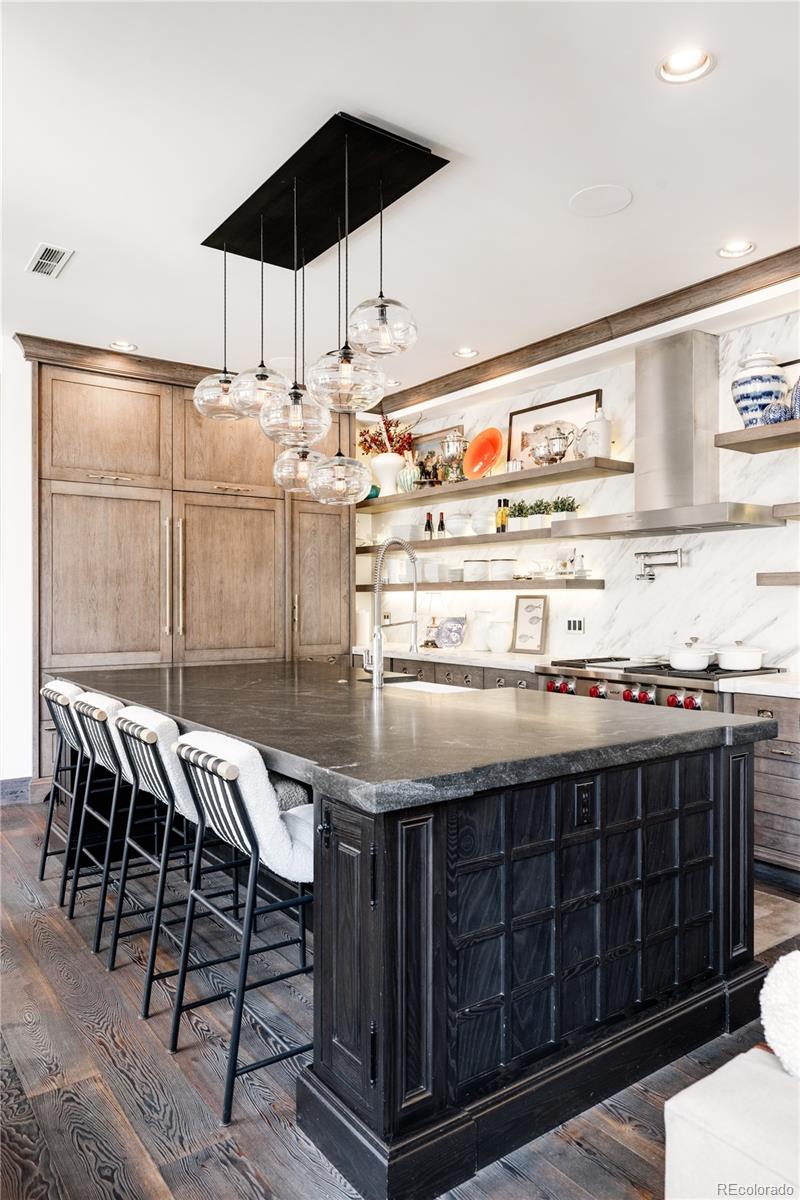 469 Cook Street Denver, CO 80206 - Photo 16 of 50 a kitchen with stainless steel appliances kitchen island a table and chairs in it