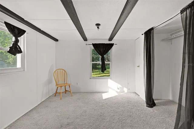 a view of a livingroom with wooden floor and a ceiling fan