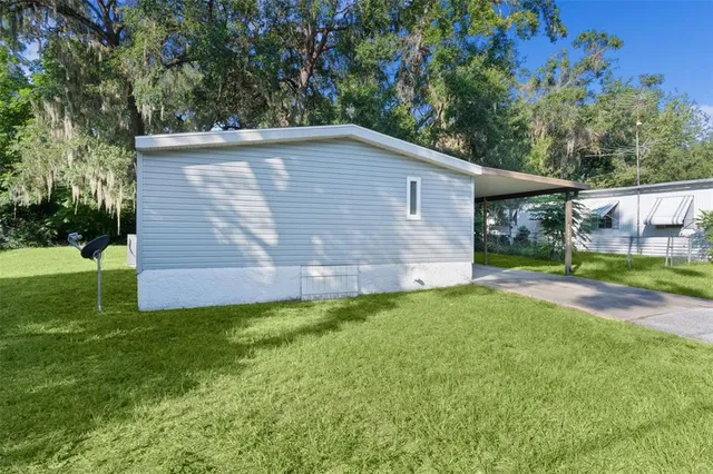 a backyard of a house with plants and large trees