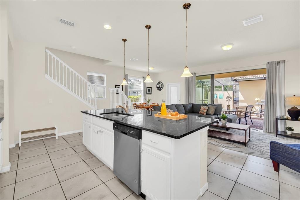 2070 Rome Drive Kissimmee, FL 34747 - Photo 12 of 57 a kitchen with stainless steel appliances kitchen island granite countertop a sink and cabinets
