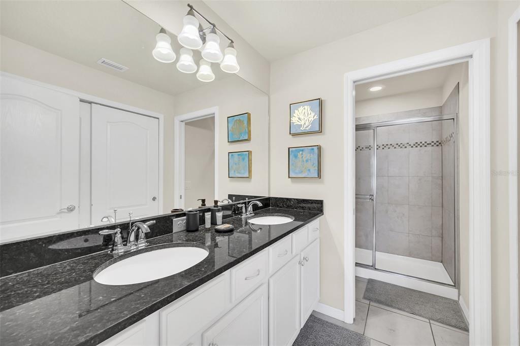 2070 Rome Drive Kissimmee, FL 34747 - Photo 33 of 57 a bathroom with a granite countertop double vanity and a mirror