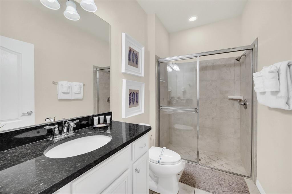 2070 Rome Drive Kissimmee, FL 34747 - Photo 38 of 57 a bathroom with a granite countertop sink toilet a mirror a vanity and shower