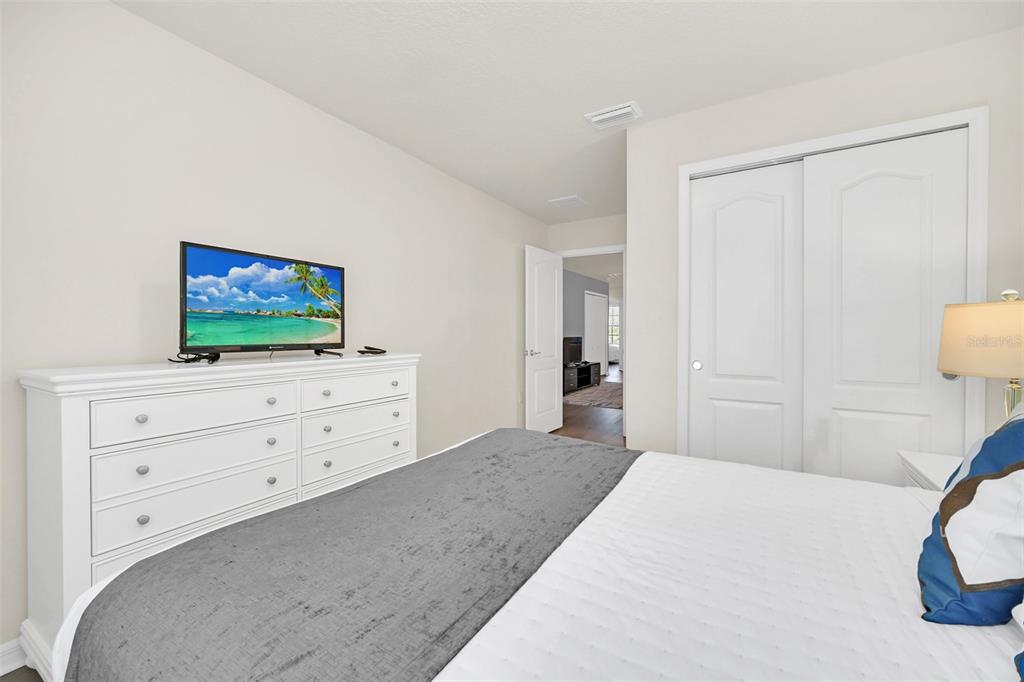 2070 Rome Drive Kissimmee, FL 34747 - Photo 40 of 57 a bedroom with a bed and a flat screen tv in white cabinet