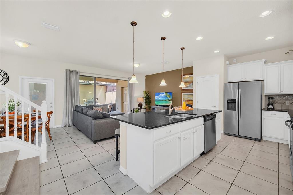2070 Rome Drive Kissimmee, FL 34747 - Photo 7 of 57 a kitchen with stainless steel appliances kitchen island granite countertop a sink and cabinets