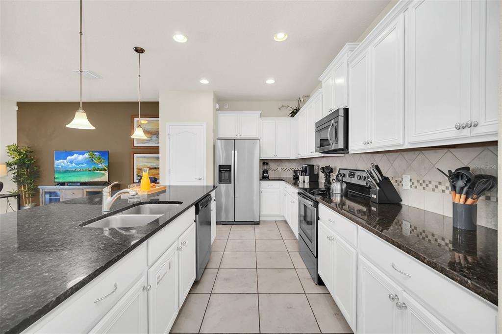 2070 Rome Drive Kissimmee, FL 34747 - Photo 9 of 57 a large kitchen with stainless steel appliances granite countertop a lot of counter space and a sink