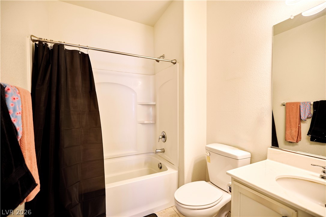 193 Tuscan Shadow Street Henderson, NV 89012 - Photo 17 of 27 This bright bathroom features a combined tub and shower unit, a vanity with a sink, and a toilet.