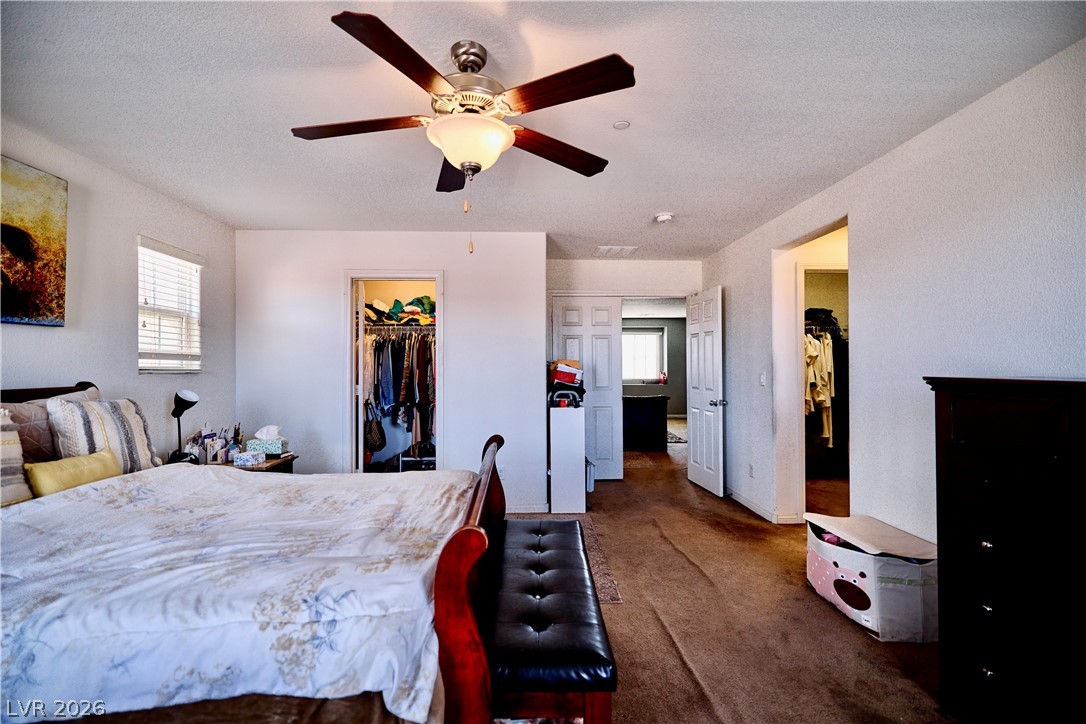 193 Tuscan Shadow Street Henderson, NV 89012 - Photo 20 of 27 This spacious bedroom offers ample comfort and convenience, featuring a ceiling fan for climate control.