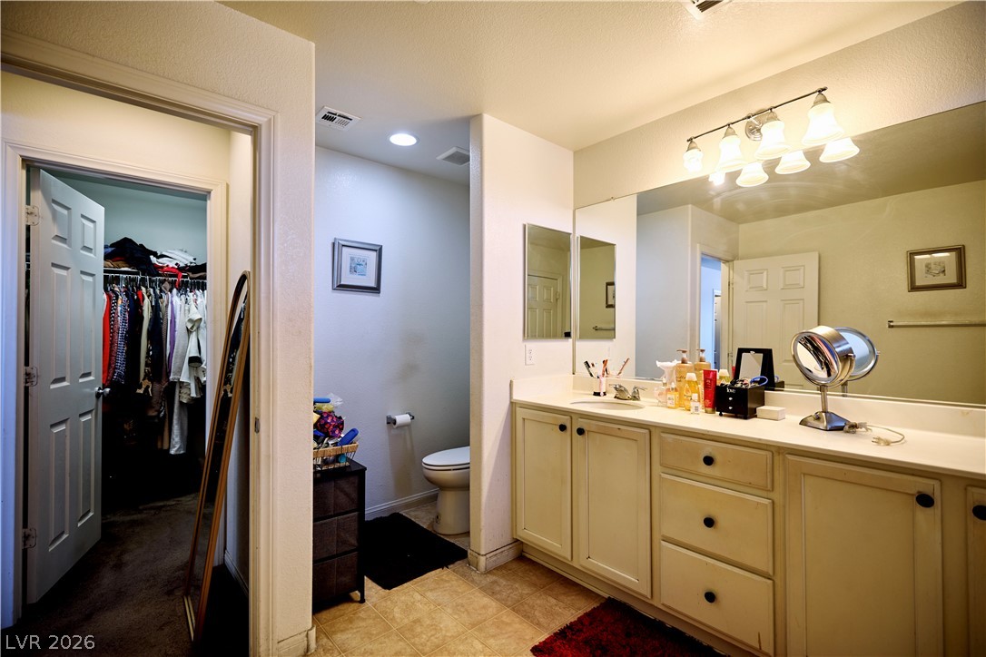 193 Tuscan Shadow Street Henderson, NV 89012 - Photo 22 of 27 This bathroom features a functional vanity with ample storage and a convenient walk-in closet.
