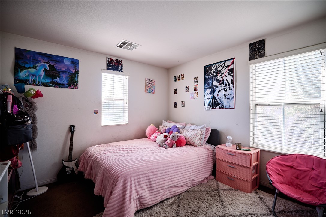 193 Tuscan Shadow Street Henderson, NV 89012 - Photo 23 of 27 This cozy upstairs bedroom offers a comfortable retreat with ample natural light.