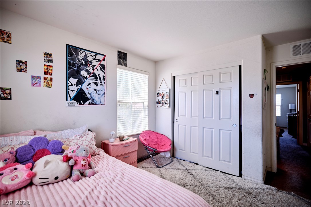 193 Tuscan Shadow Street Henderson, NV 89012 - Photo 24 of 27 This bedroom offers comfort and a well-lit space with a clean aesthetic.
