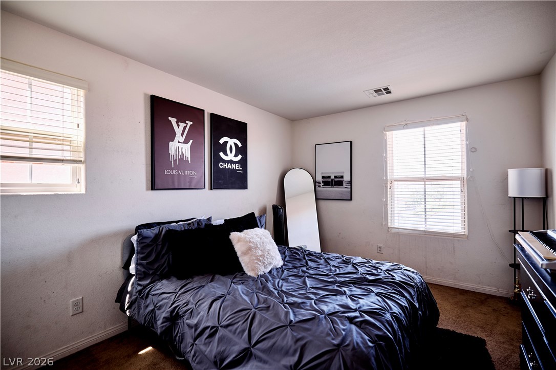 193 Tuscan Shadow Street Henderson, NV 89012 - Photo 26 of 27 This cozy upstairs bedroom provides a comfortable and inviting atmosphere, perfect for rest and relaxation.