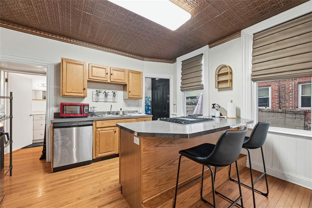 110 South 13th Street Pittsburgh, PA 15203 - Photo 11 of 36 a kitchen with stainless steel appliances granite countertop a stove a sink dishwasher and cabinets with wooden floor