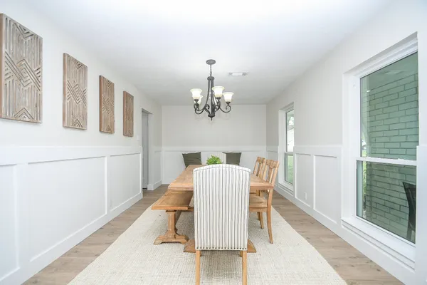 a view of a dining room with furniture a chandelier and wooden floor