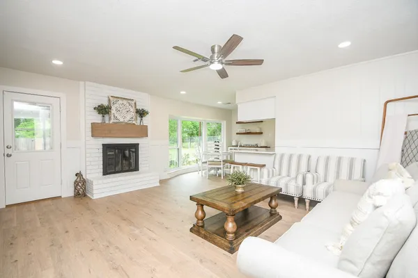 a living room with furniture a fireplace and a large window