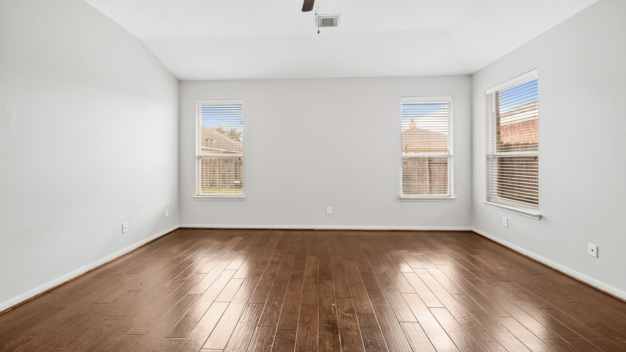 15710 Flagstone Walk Way Houston, TX 77049 - Photo 11 of 27 an empty room with wooden floor and windows
