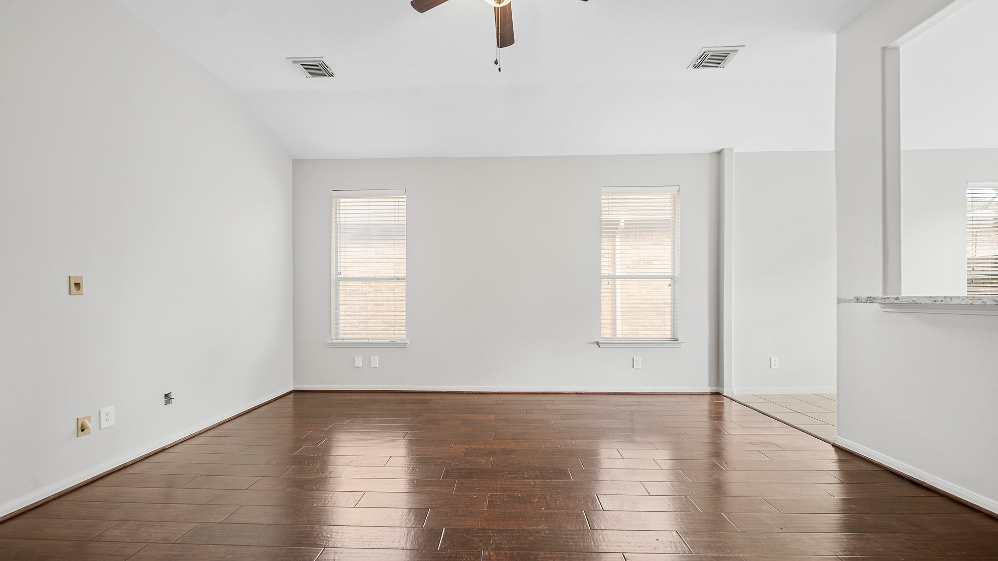 15710 Flagstone Walk Way Houston, TX 77049 - Photo 12 of 27 an empty room with wooden floor and windows