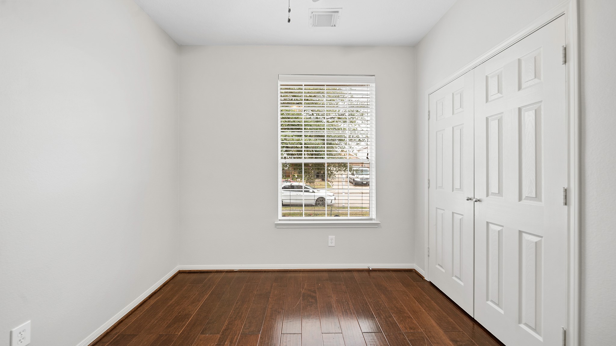 15710 Flagstone Walk Way Houston, TX 77049 - Photo 16 of 27 an empty room with wooden floor and windows