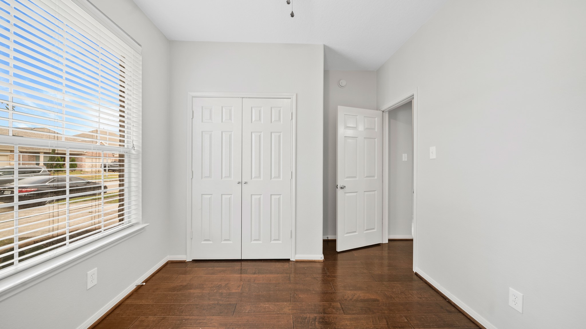 15710 Flagstone Walk Way Houston, TX 77049 - Photo 17 of 27 a view of an empty room with wooden floor and a window