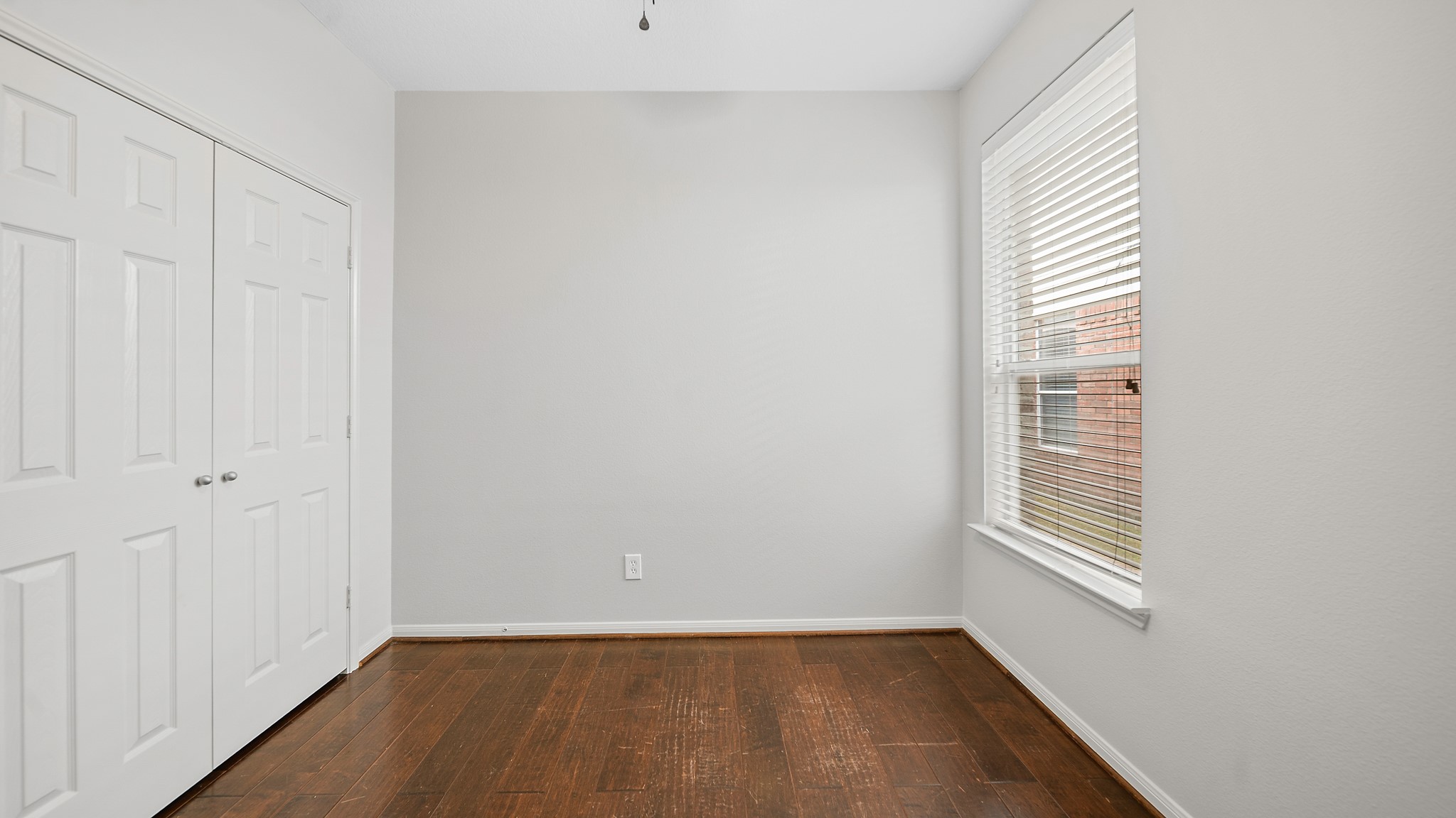 15710 Flagstone Walk Way Houston, TX 77049 - Photo 18 of 27 a view of an empty room with wooden floor and a window