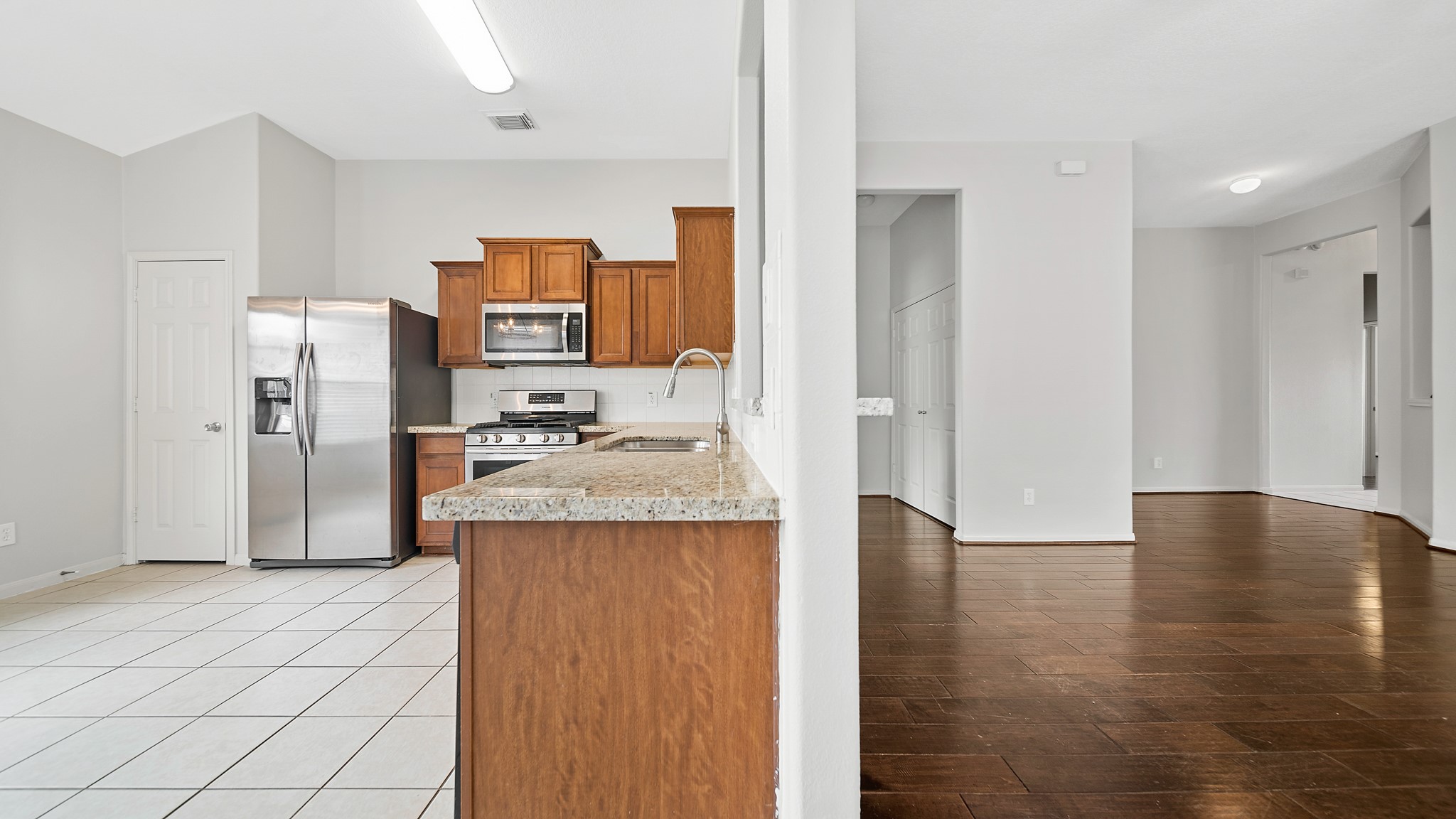 15710 Flagstone Walk Way Houston, TX 77049 - Photo 7 of 27 a kitchen with stainless steel appliances granite countertop a refrigerator and a sink