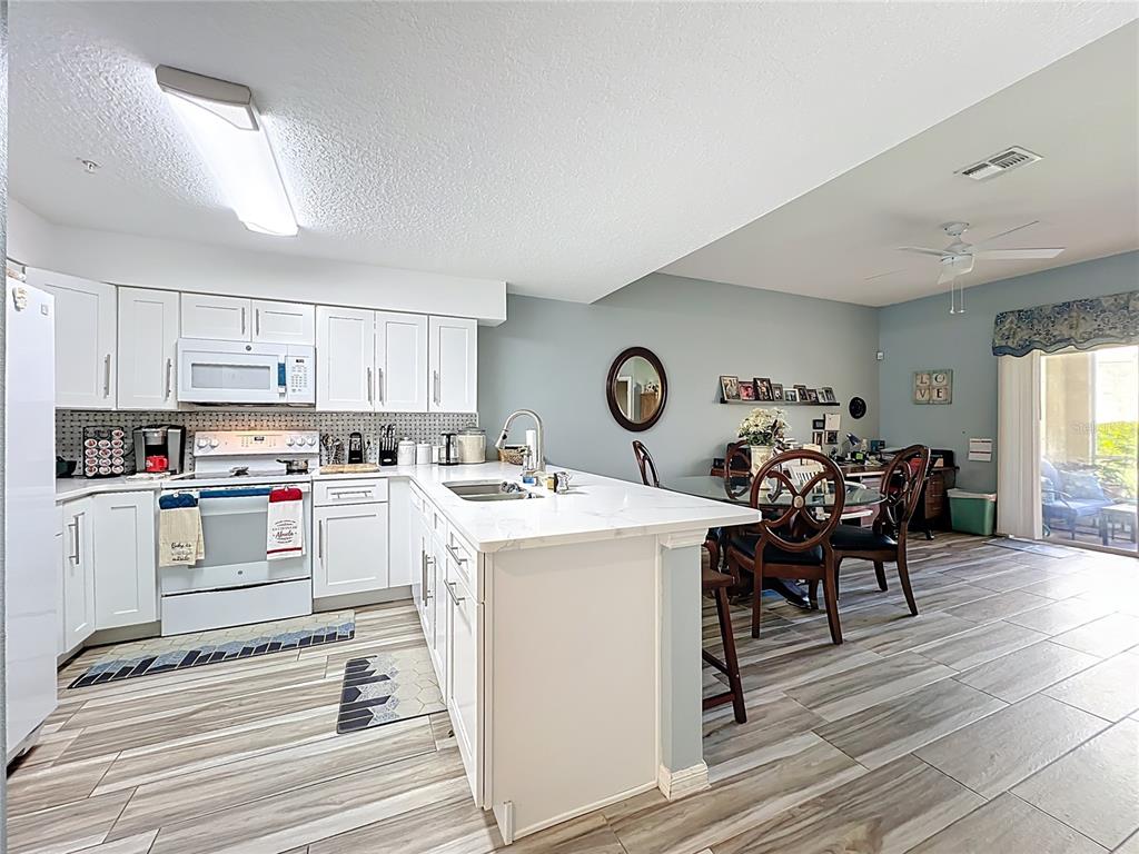 676 Sandy Neck Lane, Unit 101 Altamonte Springs, FL 32714 - Photo 7 of 24 a kitchen with a stove and white cabinets
