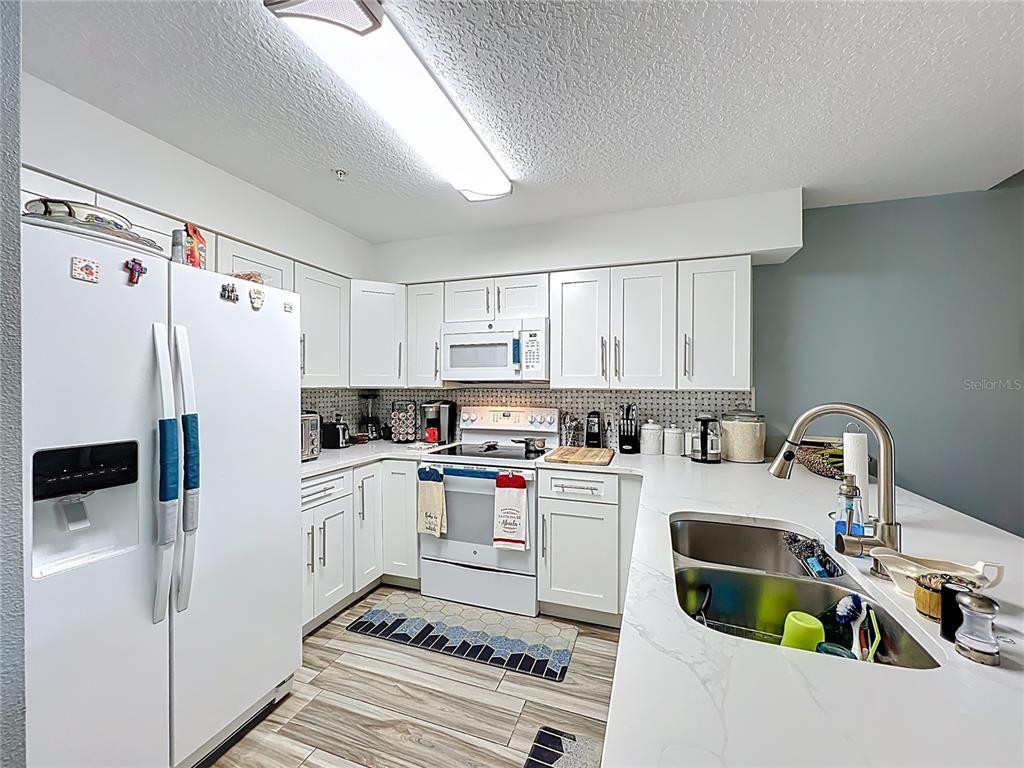 676 Sandy Neck Lane, Unit 101 Altamonte Springs, FL 32714 - Photo 8 of 24 a kitchen with stainless steel appliances a refrigerator sink and cabinets