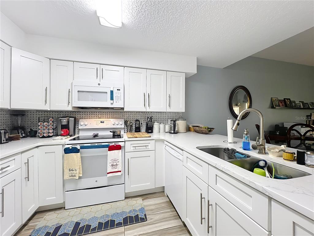 676 Sandy Neck Lane, Unit 101 Altamonte Springs, FL 32714 - Photo 9 of 24 a kitchen with white cabinets stainless steel appliances and sink