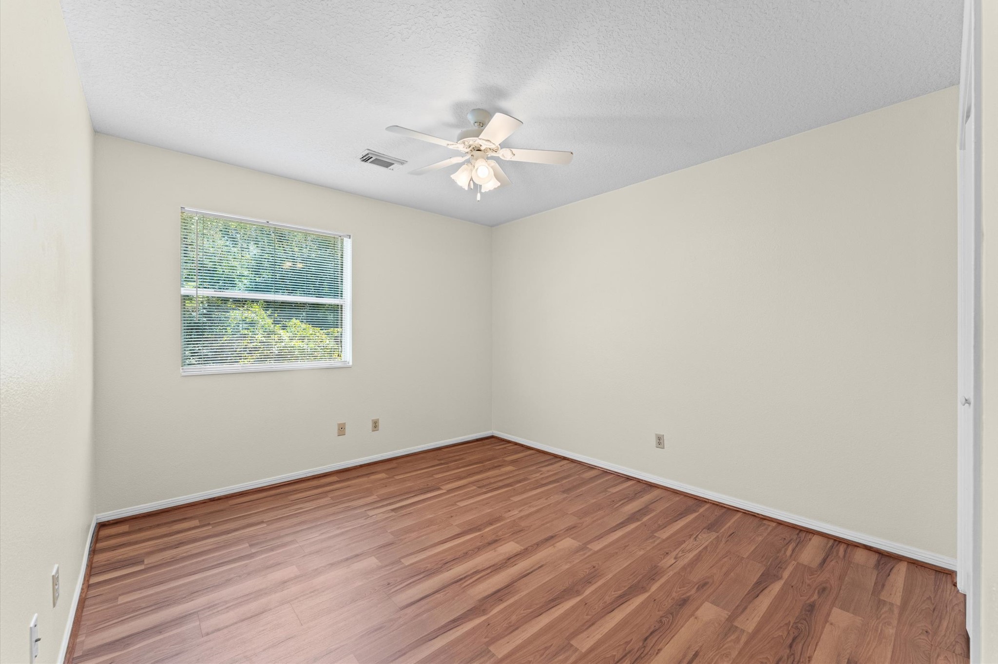 4 Blue Fox Court Spring, TX 77380 - Photo 9 of 13 The first secondary bedroom has a ceiling fan, wood-look flooring, and a large window