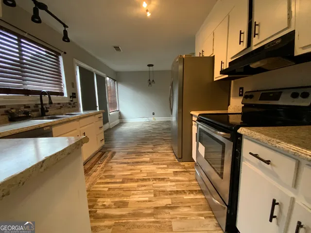 a kitchen with stainless steel appliances granite countertop a sink and a stove