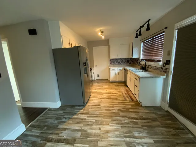 a kitchen with stainless steel appliances granite countertop a refrigerator a stove and a sink