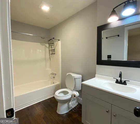 a bathroom with a toilet sink a mirror and bathtub