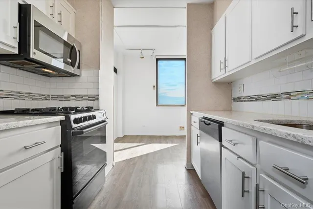 a kitchen with stainless steel appliances granite countertop a stove and a microwave