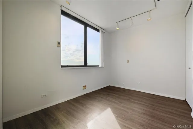 a view of a small space with wooden floor and a window