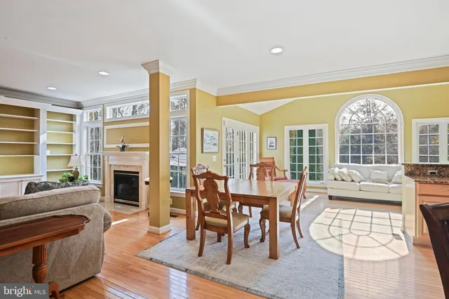 a kitchen with stainless steel appliances granite countertop a stove top oven a refrigerator and a microwave with wooden floor