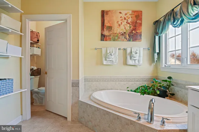 a bathroom with a tub sink and mirror
