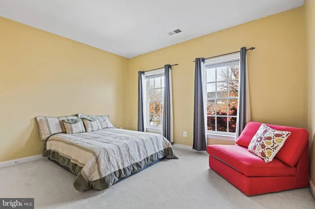 a bedroom with a bed and a dresser next to a window