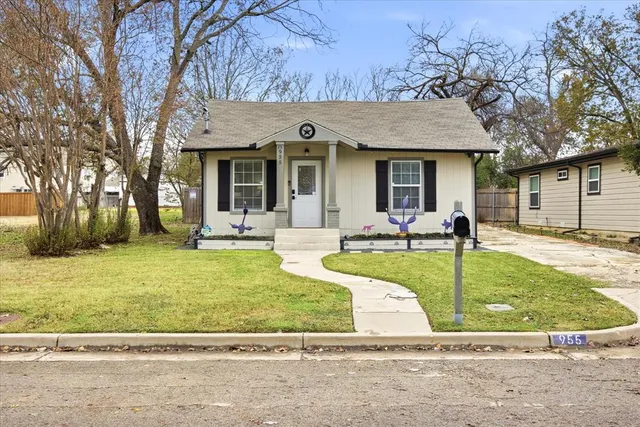 a view of a house with backyard and tree