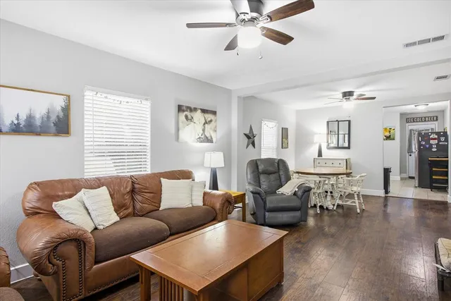 a living room with furniture wooden floor and window