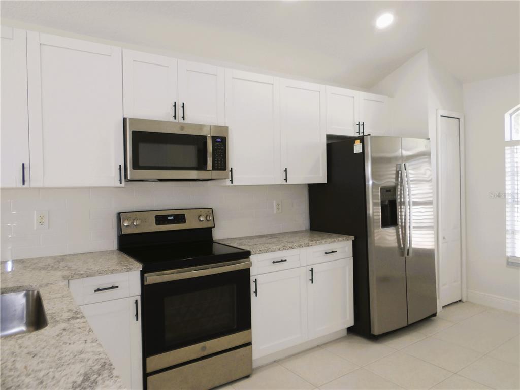 2324 Potomac Mark Place Ruskin, FL 33570 - Photo 16 of 38 a kitchen with a refrigerator stove and microwave